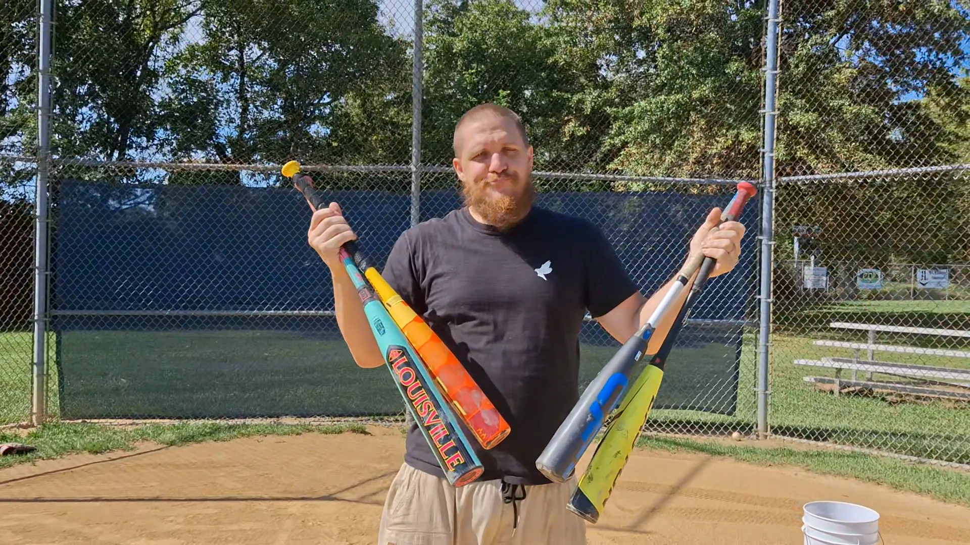 John Gruber holding 4 expensive bats